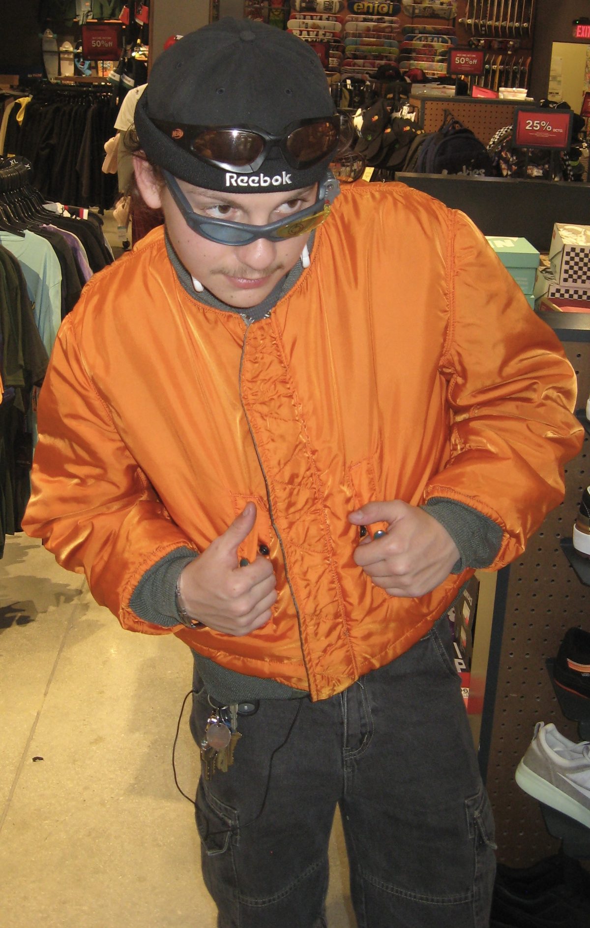 Javier, the owner of False Vintage, in an orange flight jacket, cap and goggles